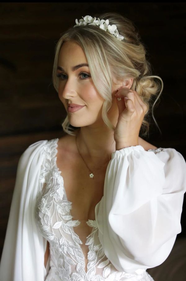 Bridal makeup on blonde bride in wedding dress with sleeves