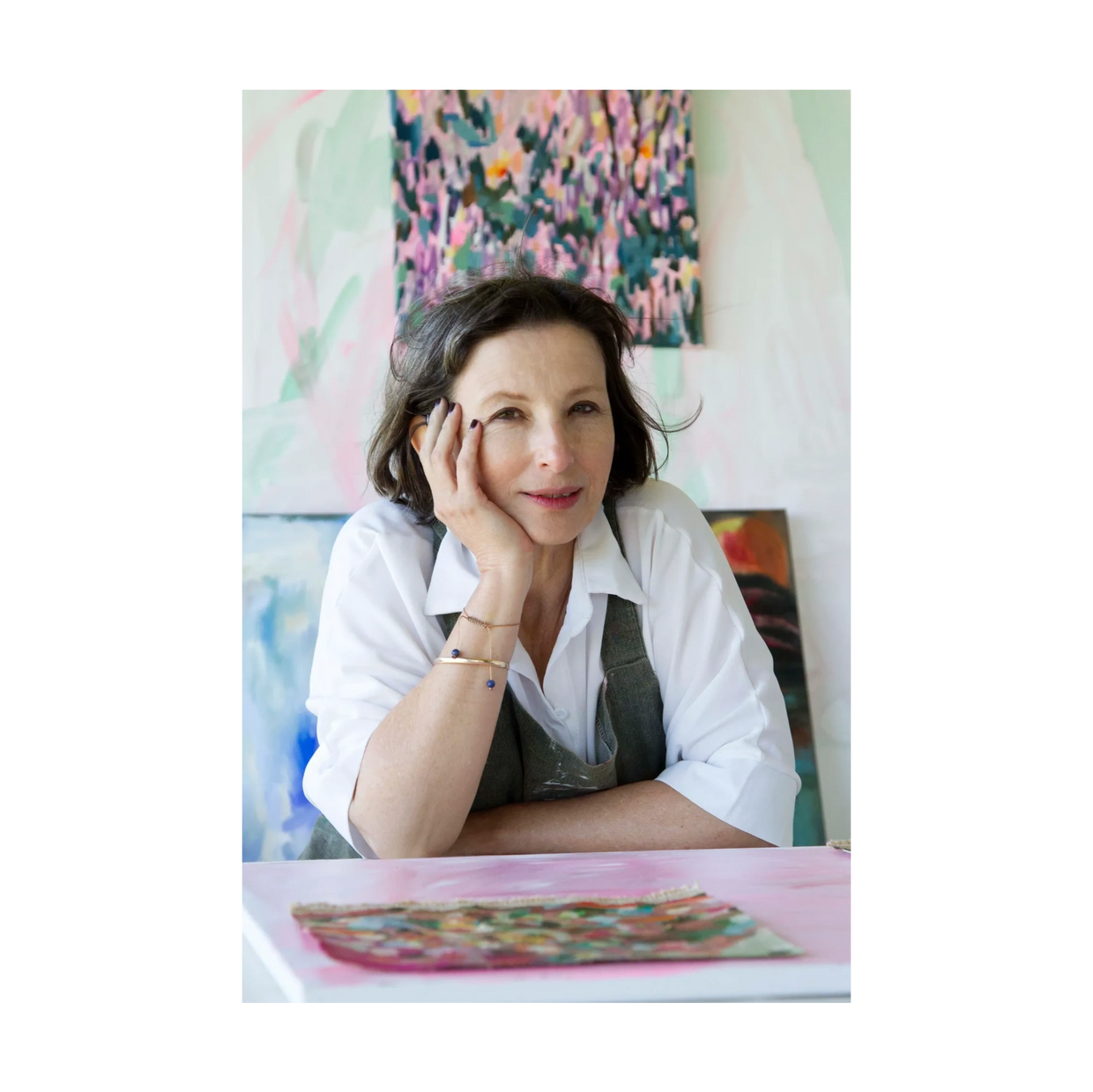 Artist Hedwig Barry sits with some of her recent paintings
