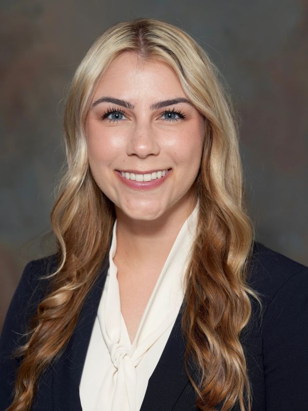 Professional portrait of a smiling woman with blonde hair.