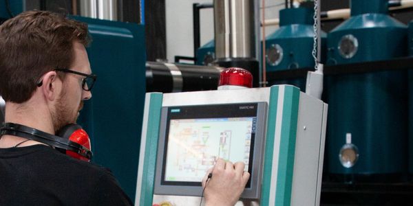 A Roasting Warehouse Employee operating on the professional coffee roasting machine.