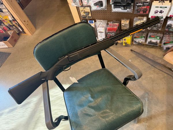 Single shotgun on a green chair in a store.