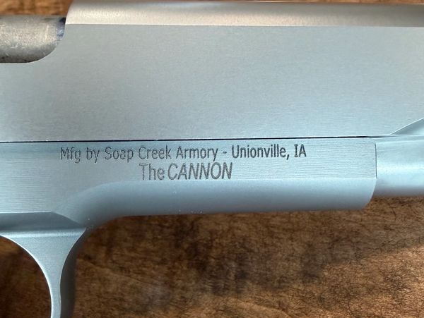 Close-up of a firearm engraving with manufacturer details.