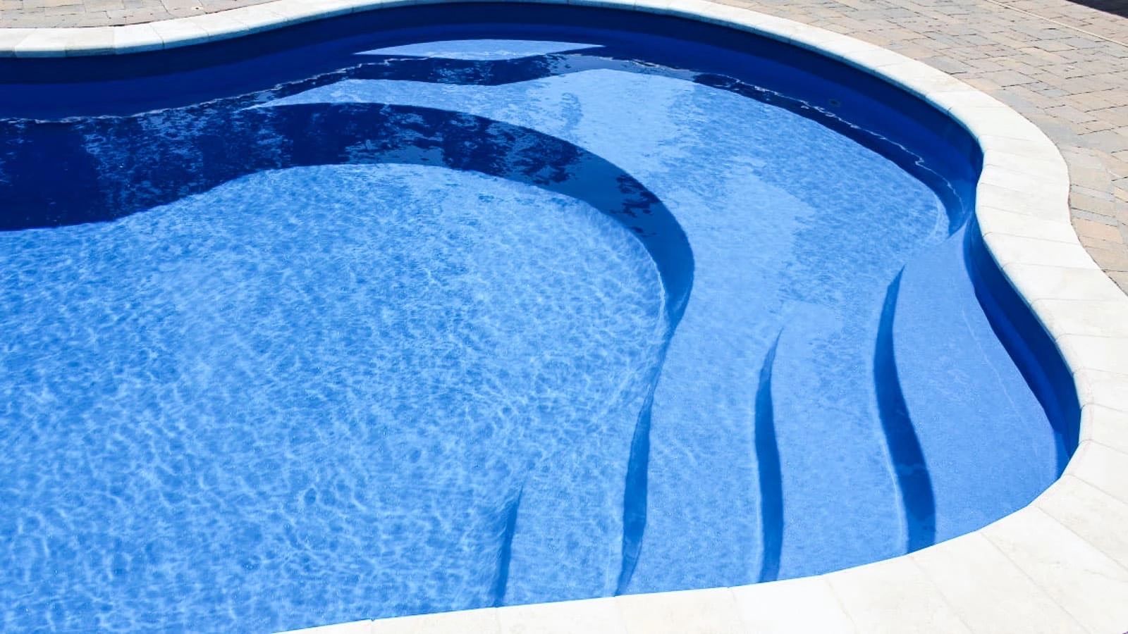 Clear blue water in a clean swimming pool with steps.