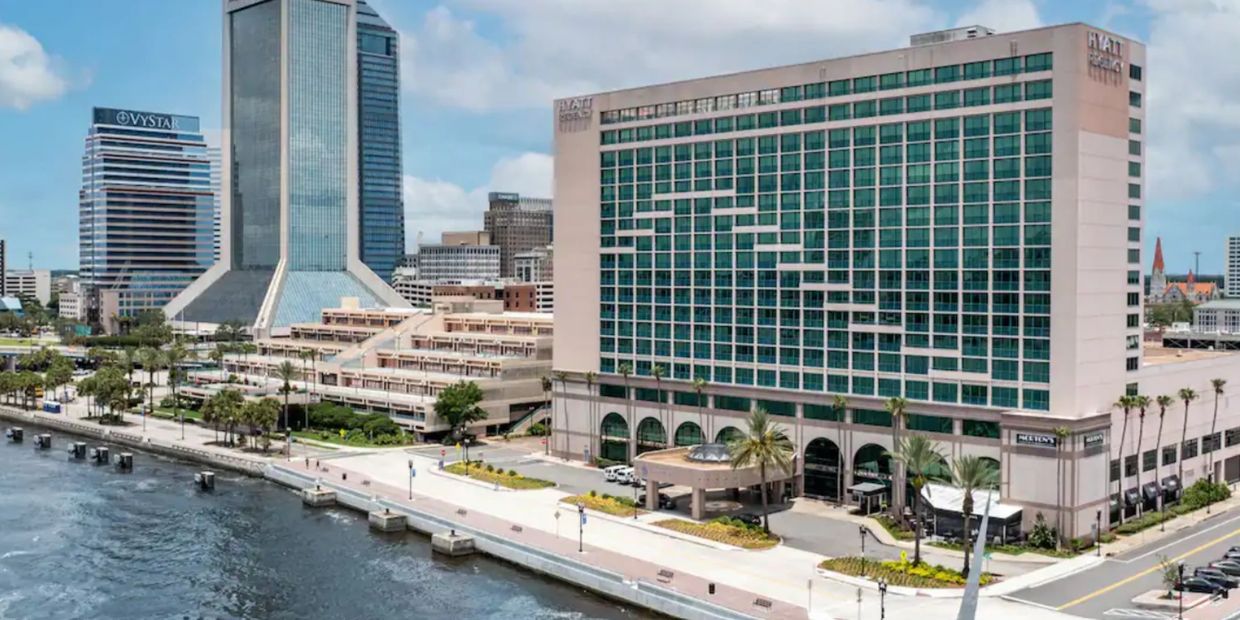Hyatt Regency hotel by a waterfront in a cityscape with modern buildings.