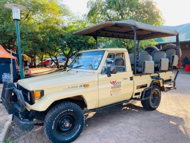 Safari tour vehicle parked outdoors.