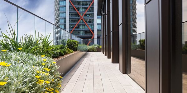 Modern rooftop terrace with plants and city view.
