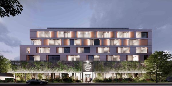 Modern hotel facade illuminated at dusk.