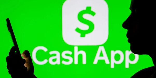 Person using a phone with Cash App logo in the background.