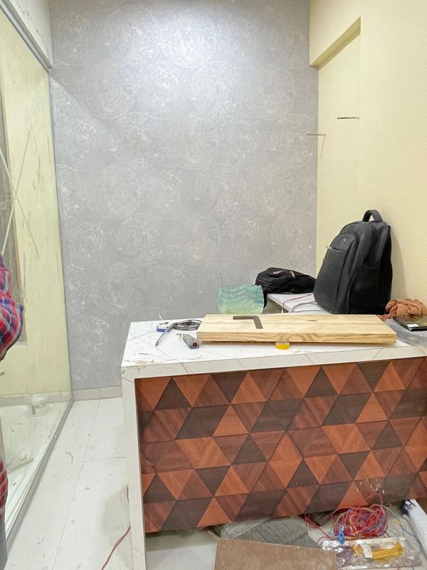 Work area with tools, wooden board, and backpacks on a patterned counter.