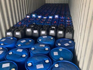 Rows of blue and black barrels tightly packed inside a shipping container.