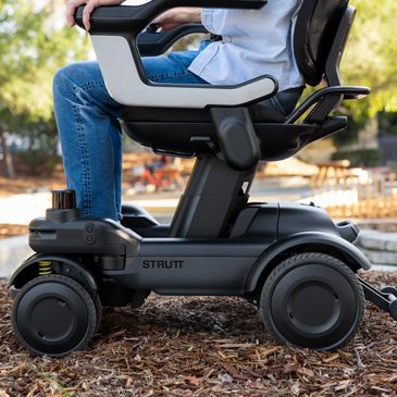 Close-up of a powered mobility scooter outdoors.