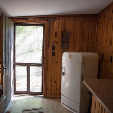 Cabin interior with screen door and fridge