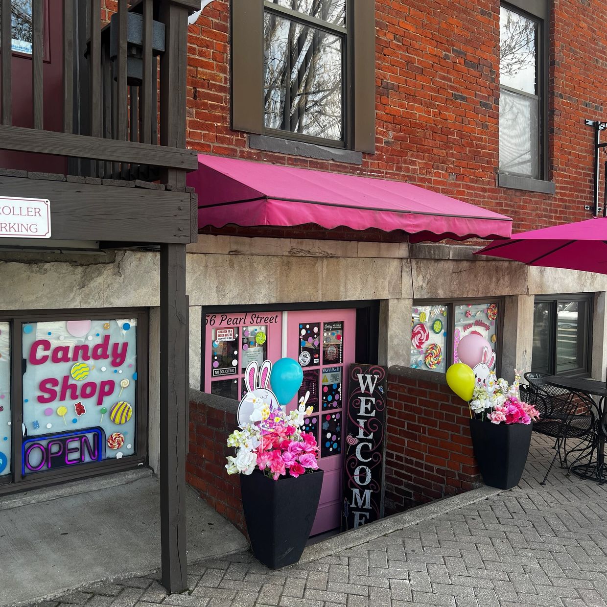 Colorful candy shop entrance with pink awning and festive decorations.