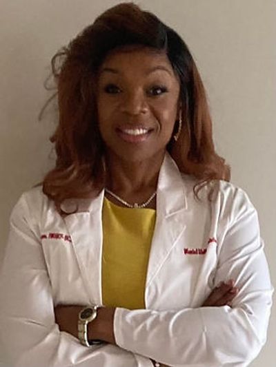 Dr. Simmons  looks forward with her hands folded
