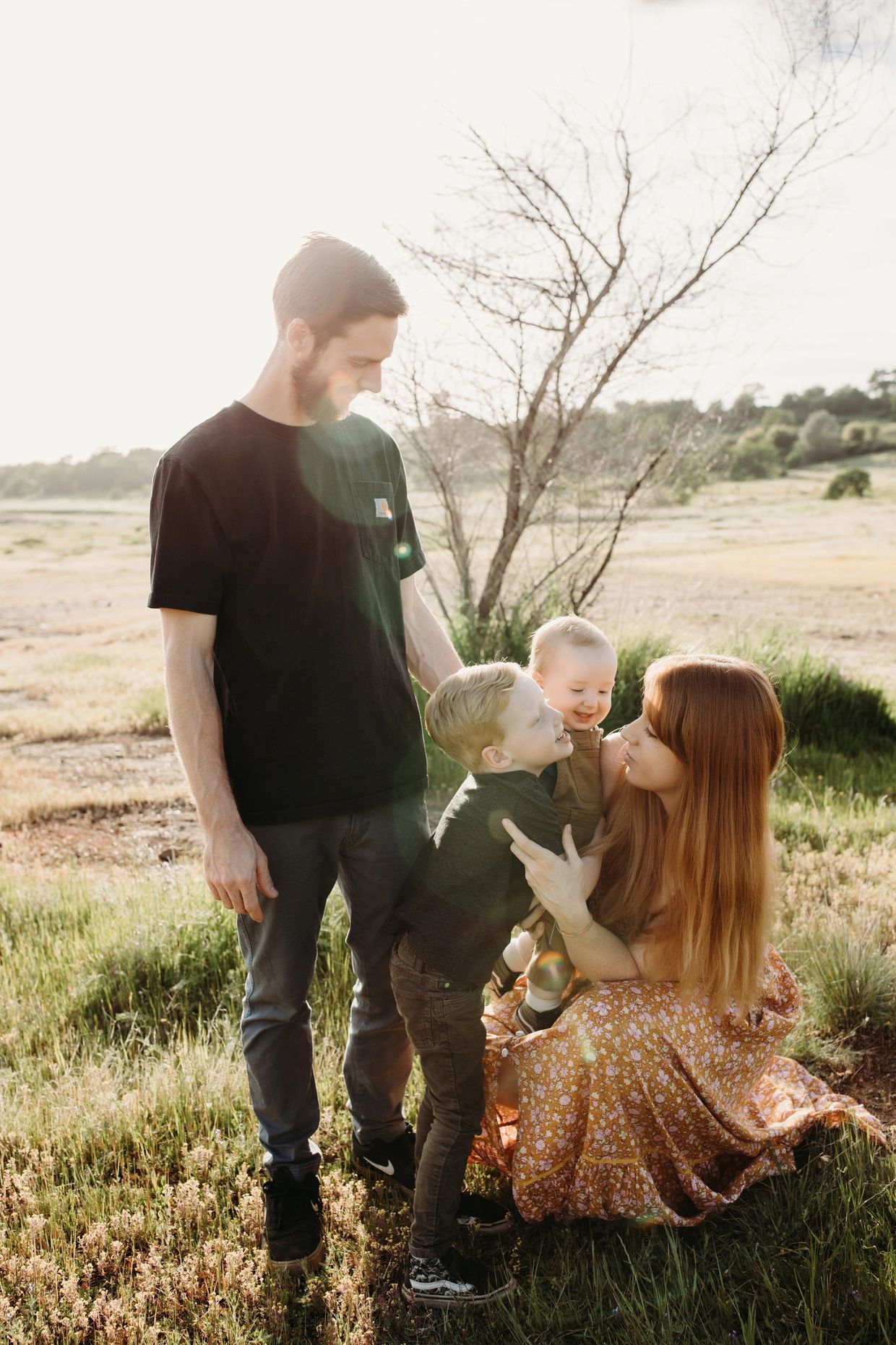 Family enjoying time outdoors in a sunny field.