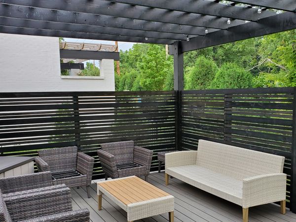 Timbertech composite decking with a black pergola and privacy screen. 