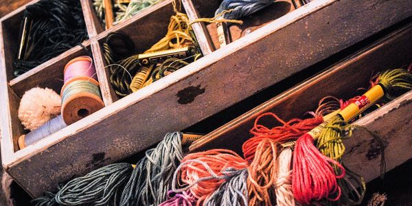 Box holding various threads and embroidery floss. 