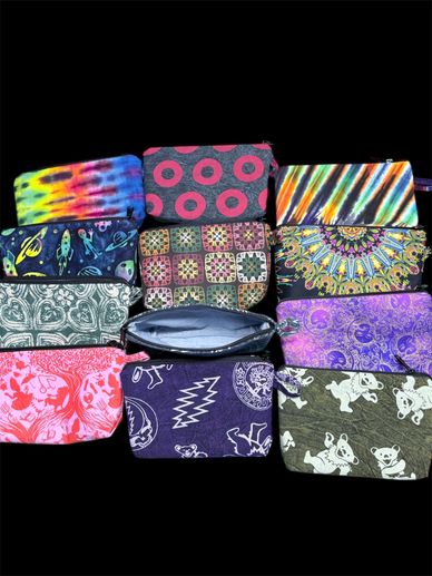 12 little zipper pouches with various prints. Grateful dead, alice in wonderland, granny square, sun