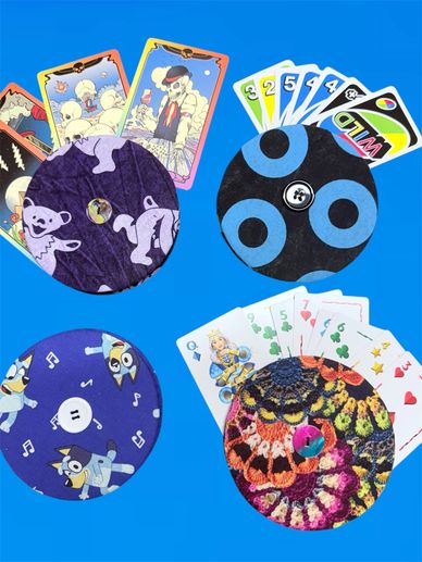 discs holding cards, 1 bear purple, 1 blue circles, 1 bluey, 1 crochet print blue background, uno