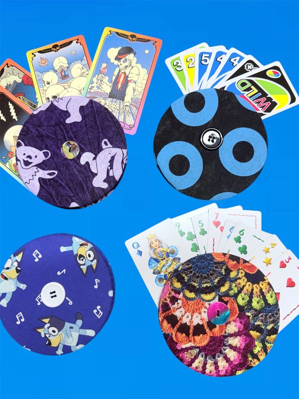 discs holding cards, 1 bear purple, 1 blue circles, 1 bluey, 1 crochet print blue background, uno