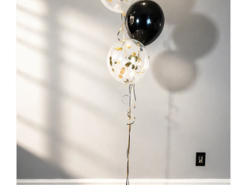 Balloons with shadows on a plain wall.