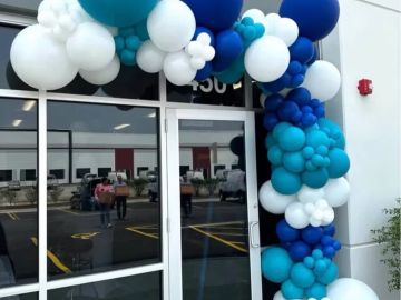 Colorful balloon arch at a building entrance.