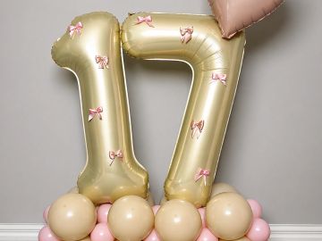 Gold balloon number 17 with pink bows and balloons.