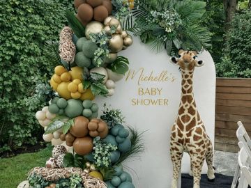 Giraffe-themed baby shower decoration with balloons.