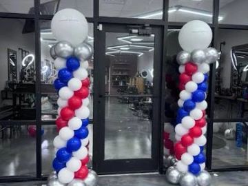 Patriotic balloon columns at a salon entrance.