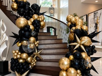 Black and gold balloon decorations along a staircase.
