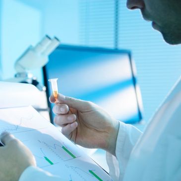 Scientist looks at vial of hemp tincture