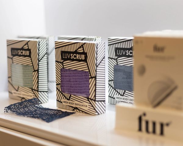 LUVSCRUB mesh body exfoliators in various colors on display.