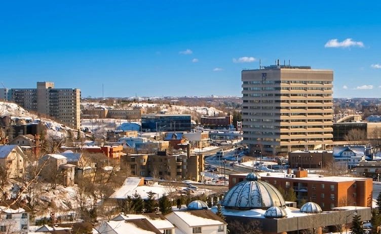 Cityscape with snow-covered buildings under a clear blue sky.