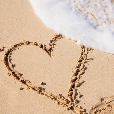 A picture of a heart in the sand.
