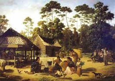 A rustic village scene with people, wooden huts, and tall trees at sunset.