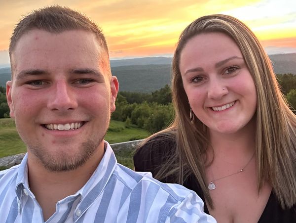 Happy couple smiling outdoors during sunset.