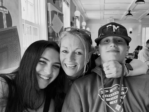 Three people smiling together indoors.