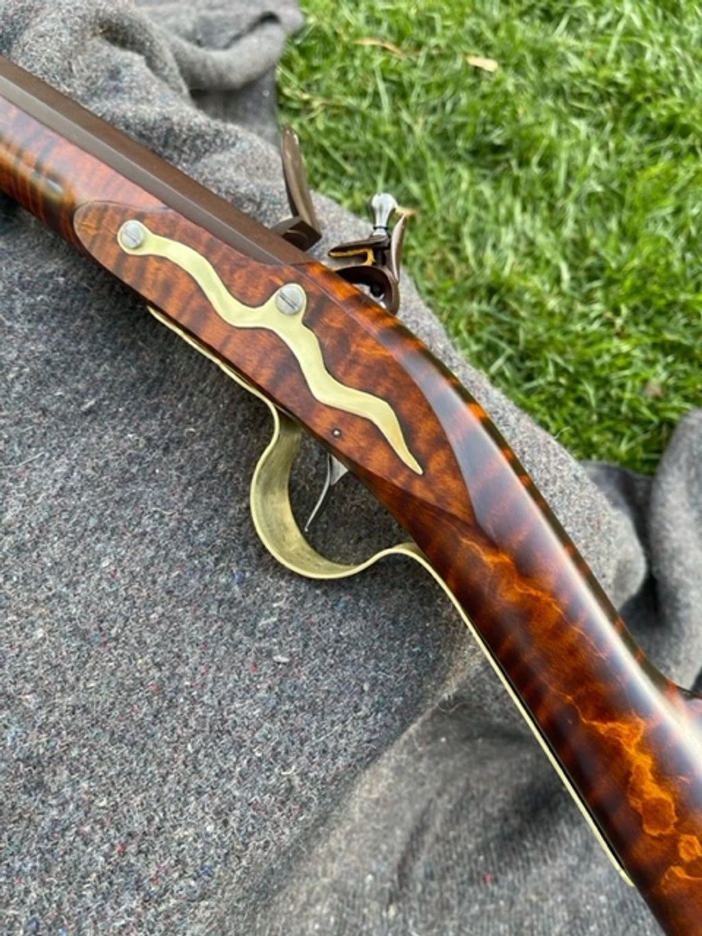 Close-up of an antique flintlock pistol with ornate wood and brass details.