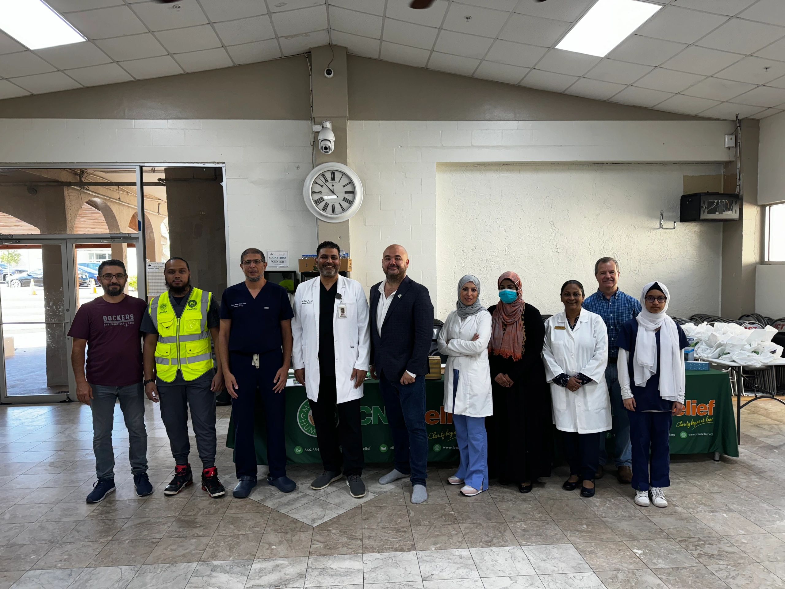 A diverse team of healthcare and support staff posing indoors.