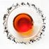 loose leaf Classically Black and infused tea in a clear glass tea cup and saucer