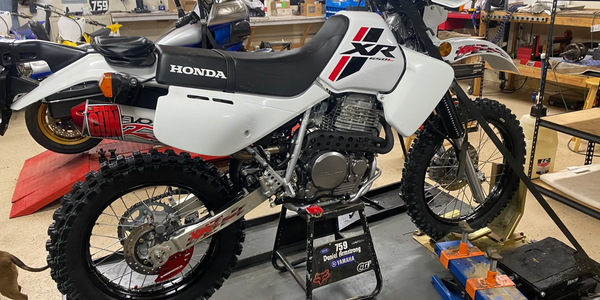 Honda XR650 dual sport motorcycle in the shop for service and new tires.