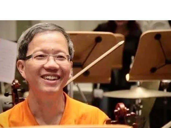 Teacher Wong playing in an orchestra.