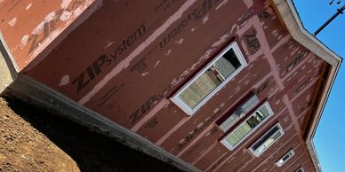 House under construction with ZIP System sheathing and new windows installed.