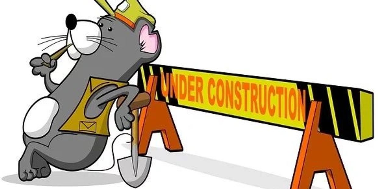 Cartoon mouse in construction gear leaning on shovel by an under construction barrier.