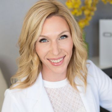 Smiling woman with blonde hair in white attire.