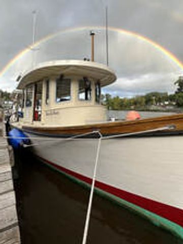 Boat docked with a vibrant rainbow arching overhead.