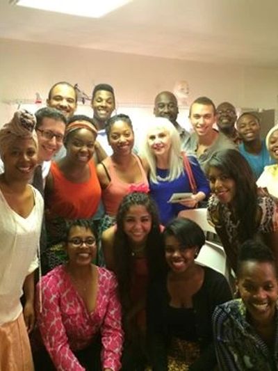 Group of smiling people posing indoors.