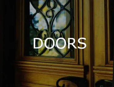 Close-up of an ornate wooden door with decorative ironwork on glass panels.