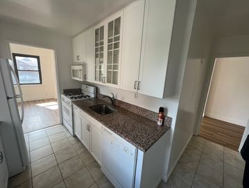 Bright kitchen with white cabinets and granite countertops.