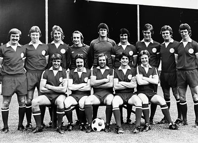 Black and white photo of a vintage soccer team posing with a ball.
